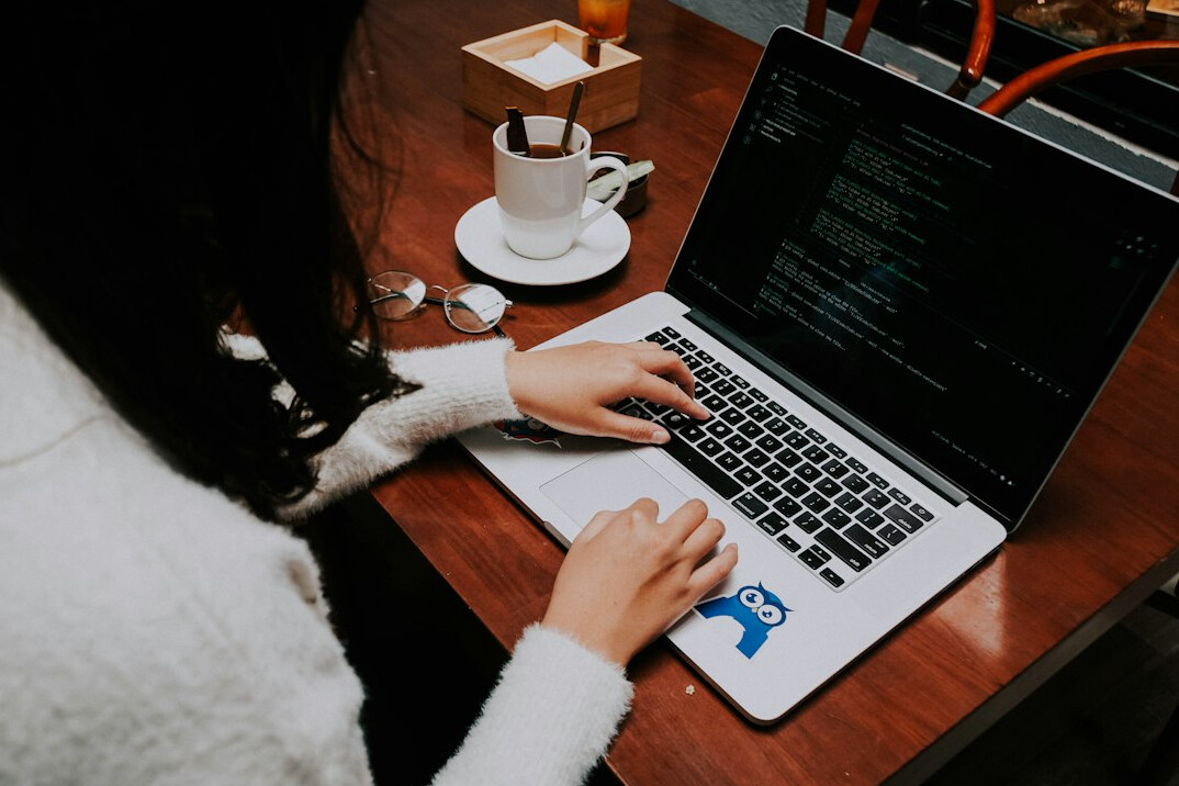 person coding on laptop